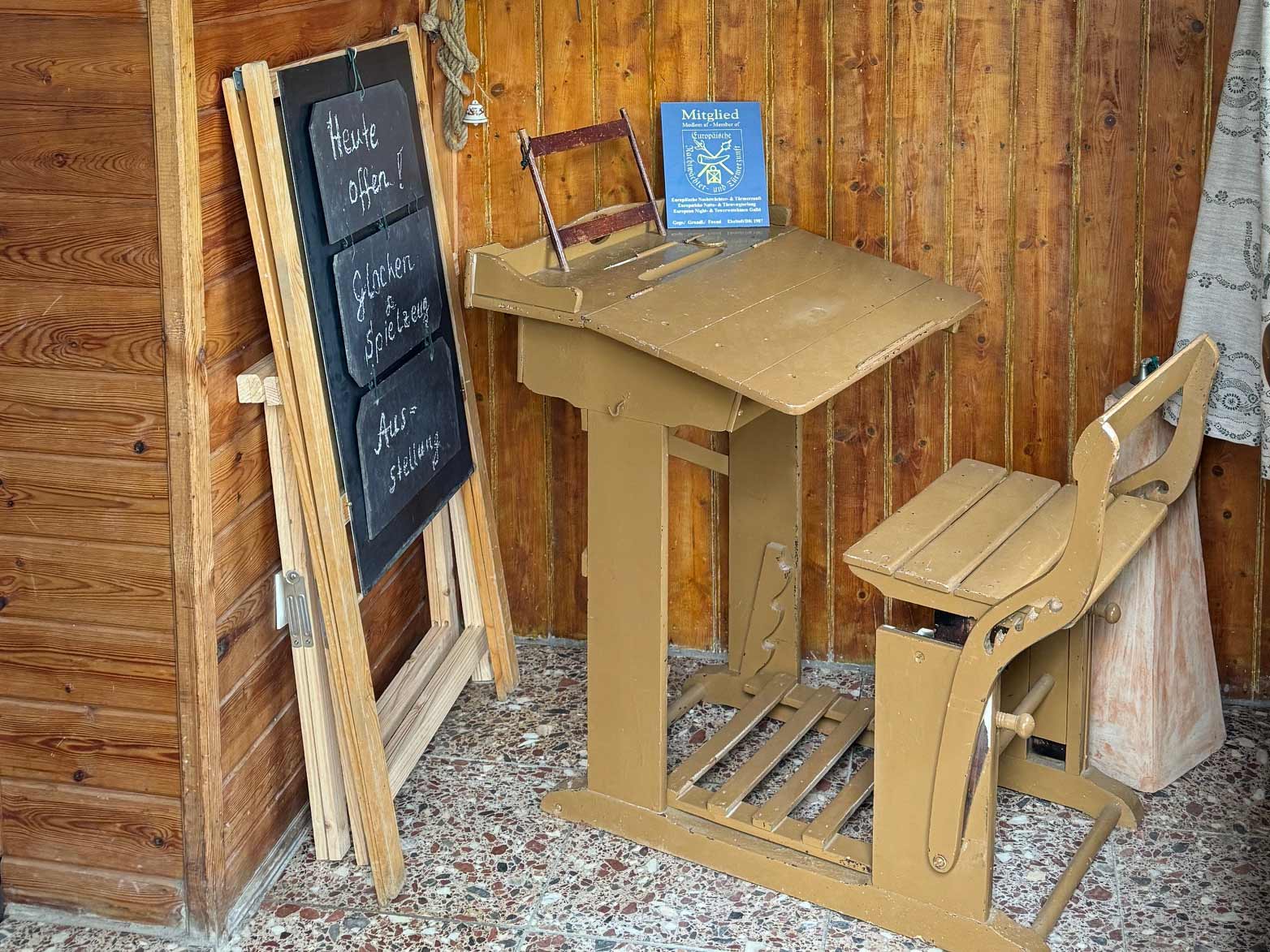 Historische Schulbank vor einer Tafel mit Hinweis auf die Glockenausstellung